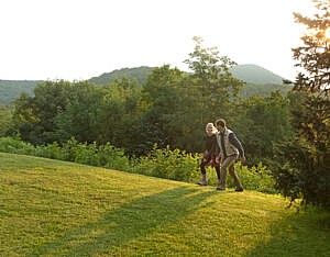 Couple walking grassy knob at The Swag, a Relais & Châteaux property